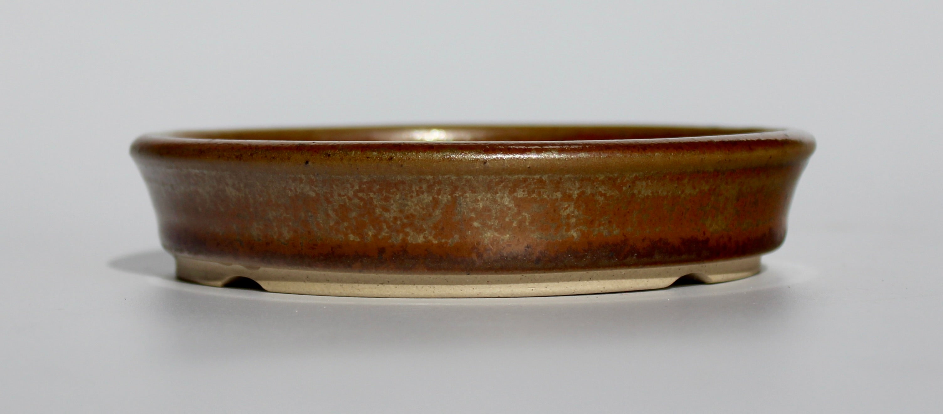 Round bonsai pot in a copper brown/orange glaze. D.133mm