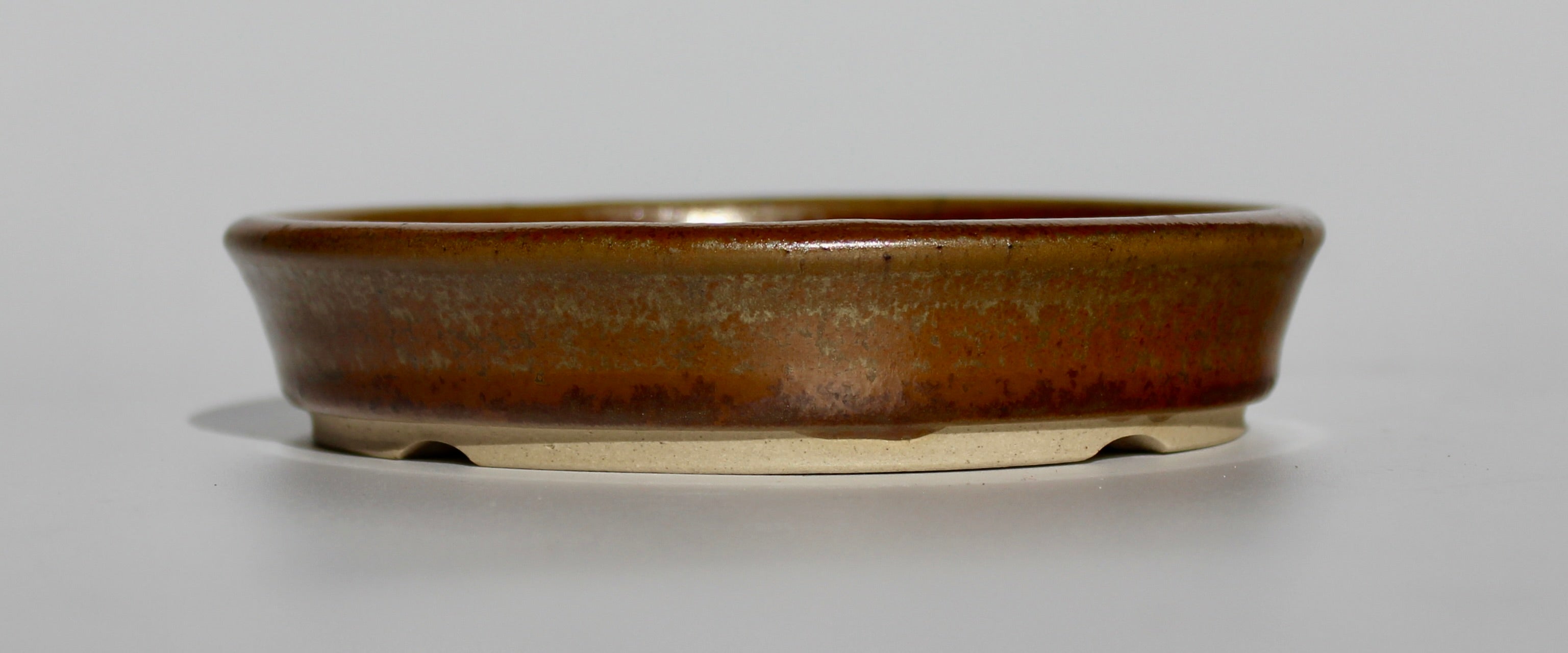 Round bonsai pot in a copper brown/orange glaze. D.133mm