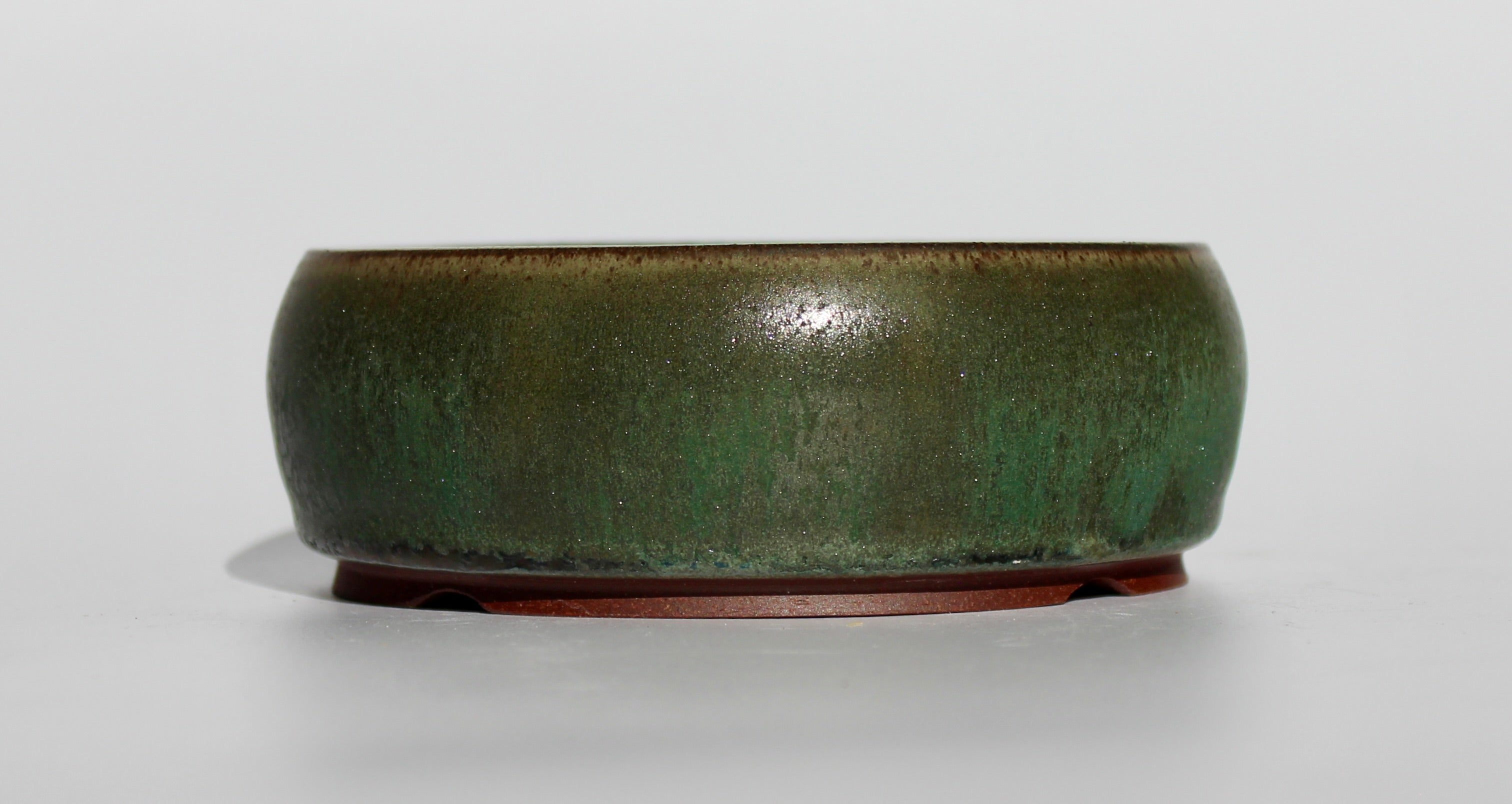 Round bonsai pot in a dark green copper glaze. D.130mm